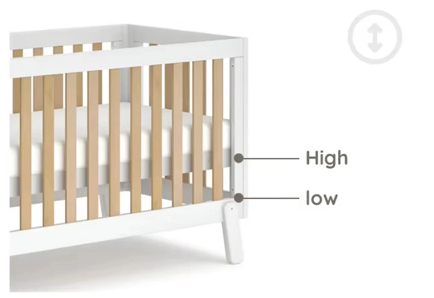 Close-up of a white cot bed side showing the high and low mattress base positions Close-up of a white cot bed side showing the high and low mattress base positions
